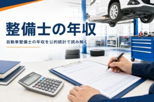 自動車整備士の年収・給料を公的統計で紹介する記事のアイキャッチ。整備工場の机に置かれた明細と電卓