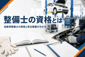 自動車整備士の資格と取る順番を紹介する記事のアイキャッチ。教科書とノートが置かれた机と整備工場