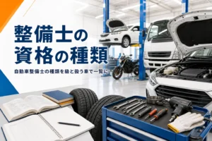 自動車整備士の資格の種類を一覧で紹介する記事のアイキャッチ。整備工場に並ぶ乗用車とトラック